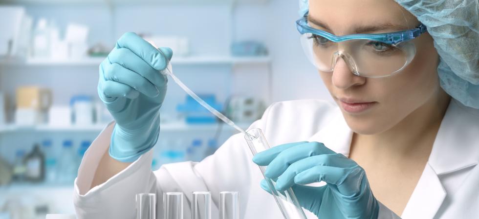 female laboratory technician fills test tube